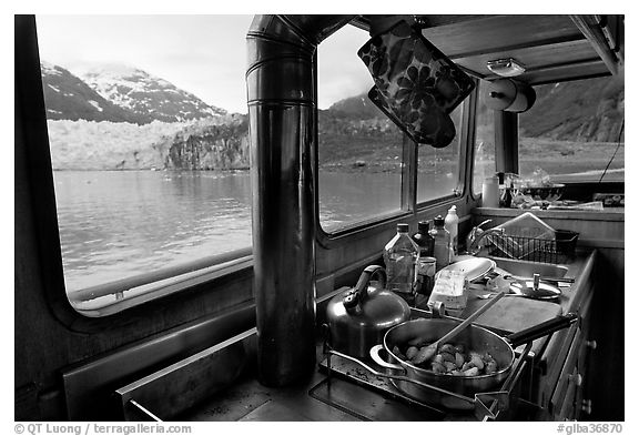 Breakfast potatoes in a small boat moored in front of glacier. Glacier Bay National Park (black and white)
