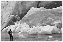 Hiker looking at ice wall at the front of Reid Glacier. Glacier Bay National Park, Alaska, USA. (black and white)