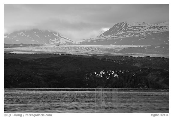 Last sunrays catched by the moraine-covered face of Grand Pacific Glacier. Glacier Bay National Park (black and white)