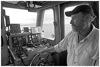 Captain steering boat with navigation instruments. Glacier Bay National Park, Alaska, USA. (black and white)