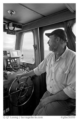 Captain steering boat using navigation instruments. Glacier Bay National Park, Alaska, USA.