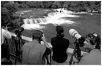 Photographers on observation platform and Brooks falls with bears. Katmai National Park, Alaska, USA. (black and white)