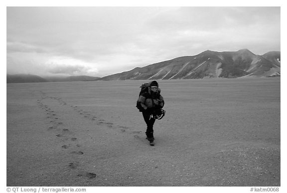 Backpacker hikes in sand-like ash, Valley of Ten Thousand smokes. Katmai National Park, Alaska