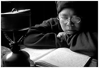 Backpacker reads log in abandonned geological survey cabin, Valley of Ten Thousand smokes. Katmai National Park, Alaska (black and white)