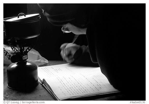 Backpacker writes into the log in USGS research cabins, Valley of Ten Thousand smokes. Katmai National Park, Alaska