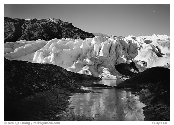 Frozen glacial pond and front of Exit Glacier, early morning. Kenai Fjords National Park, Alaska, USA.