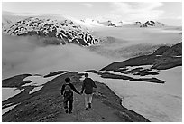 Couple hiking down Harding Icefied trail, late afternoon. Kenai Fjords National Park, Alaska, USA. (black and white)