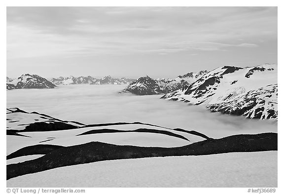 Dark bands of freshly uncovered terrain, snow, and low clouds, dusk. Kenai Fjords National Park (black and white)