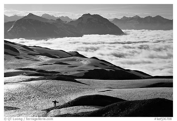 Mountains with snowboarder hiking down on snow-covered trail. Kenai Fjords National Park (black and white)