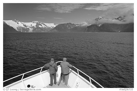 Passengers with red jackets on bow of tour boat, Northwestern Fjord. Kenai Fjords National Park (black and white)