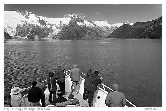 Vistors on bow of tour boat approaching glacier, Northwestern Fjord. Kenai Fjords National Park, Alaska, USA.