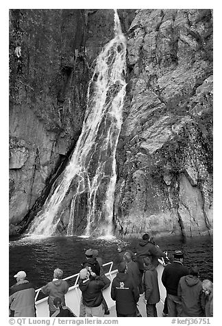 Passengers look at waterfall from tour boat, Cataract Cove, Northwestern Fjord. Kenai Fjords National Park (black and white)