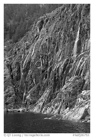 Waterfalls streaming into cove, Northwestern Fjord. Kenai Fjords National Park, Alaska, USA.