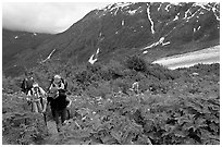 Women with child carrier backpacks on Harding Icefield trail. Kenai Fjords National Park, Alaska, USA. (black and white)