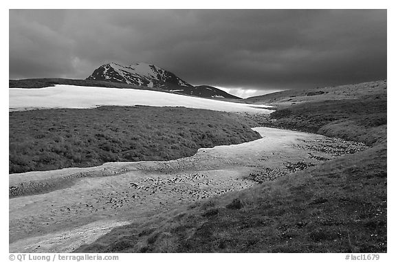 Snow nevesand mountains under dark storm clouds. Lake Clark National Park, Alaska, USA.