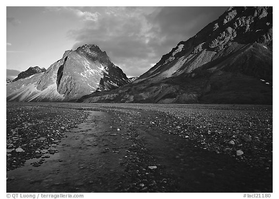 Stream on wide gravel bar and peaks at sunset. Lake Clark National Park, Alaska, USA.