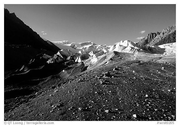 Morainic debris on Root glacier with Wrangell mountains in the background, late afternoon. Wrangell-St Elias National Park (black and white)