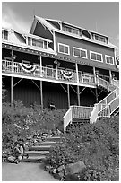 Hiker sitting on steps of Kennicott Lodge. Wrangell-St Elias National Park ( black and white)