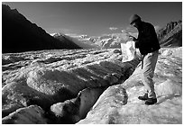 Hiker checks map on Root Glacier. Wrangell-St Elias National Park, Alaska, USA. (black and white)