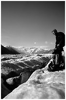 Hiker reaches for item in backpack on Root Glacier. Wrangell-St Elias National Park ( black and white)