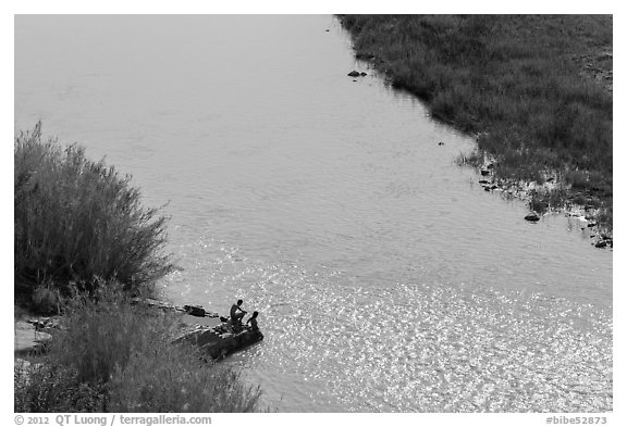 Couple sitting on edge of hot springs seen from above. Big Bend National Park, Texas, USA.