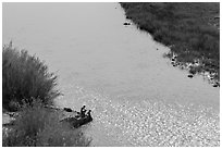 Couple sitting on edge of hot springs seen from above. Big Bend National Park, Texas, USA. (black and white)