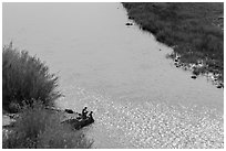 Couple sitting on edge of hot springs seen from above. Big Bend National Park, Texas, USA. (black and white)
