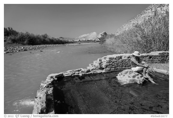 Tourist sitting in hot springs next to river. Big Bend National Park (black and white)