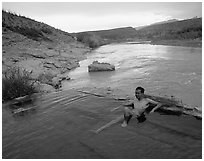 Visitor relaxes in hot springs next to Rio Grande. Big Bend National Park, Texas, USA. (black and white)