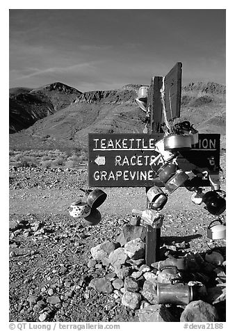 Teakettle Junction sign, adorned with teakettles. Death Valley National Park (black and white)