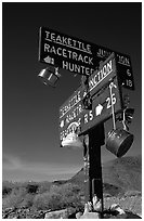 Tea kettle Junction sign, adorned with tea kettles. Death Valley National Park ( black and white)