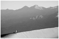 Photographer on dune ridge at sunrise. Death Valley National Park ( black and white)