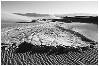 Cracked mud and sand ripples, Mesquite Sand Dunes, early morning. Death Valley National Park, California, USA. (black and white)