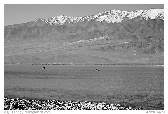 Kayakers in ephemeral Manly lake, and Panamint Range. Death Valley National Park, California, USA.