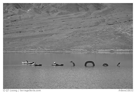 Kayakers approaching the dragon in the rare Manly Lake. Death Valley National Park (black and white)