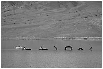 Kayakers approaching the dragon in the rare Manly Lake. Death Valley National Park ( black and white)