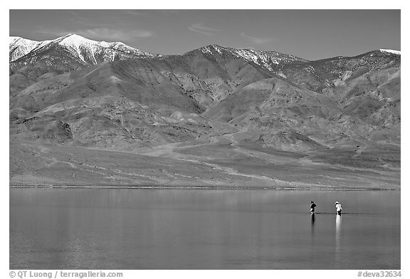 Tourists wading in the rare seasonal lake. Death Valley National Park, California, USA.