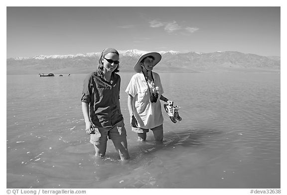 Women wading in the knee-deep seasonal lake. Death Valley National Park, California, USA.