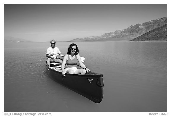 Canoists in rarely formed Manly Lake with Black Mountains in the background. Death Valley National Park, California, USA.