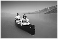 Canoists in rarely formed Manly Lake with Black Mountains in the background. Death Valley National Park, California, USA. (black and white)