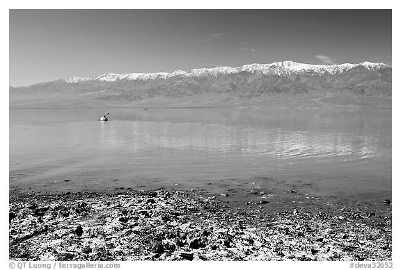 Salt formations, kayaker in a distance, and Panamint range. Death Valley National Park, California, USA.