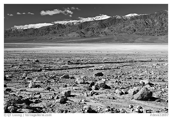 Rock field, salt flats, and Panamint Range, morning. Death Valley National Park, California, USA.