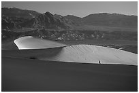 Hiker on ridge, Mesquite Dunes, sunrise. Death Valley National Park ( black and white)