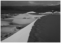 Hiker on a ridge in the Mesquite Dunes, sunrise. Death Valley National Park ( black and white)