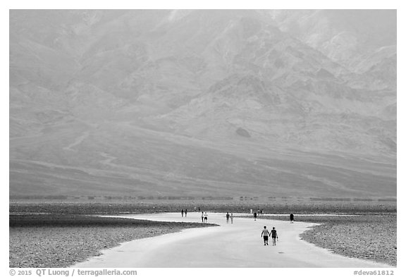 Tourists walking onto Salt Pan at Badwater. Death Valley National Park (black and white)