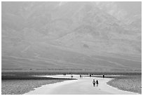 Tourists walking onto Salt Pan at Badwater. Death Valley National Park ( black and white)