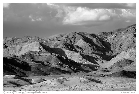 Distant Ibex Dunes at the base of multicolored mountains. Death Valley National Park (black and white)