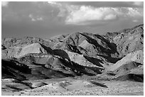 Distant Ibex Dunes at the base of multicolored mountains. Death Valley National Park ( black and white)