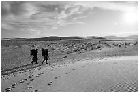 Backpackers hiking on Backcountry Trail in late afternoon. White Sands National Park ( black and white)