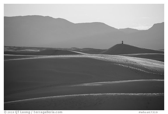 Photographer with tripod on tall dune at sunset. White Sands National Park (black and white)